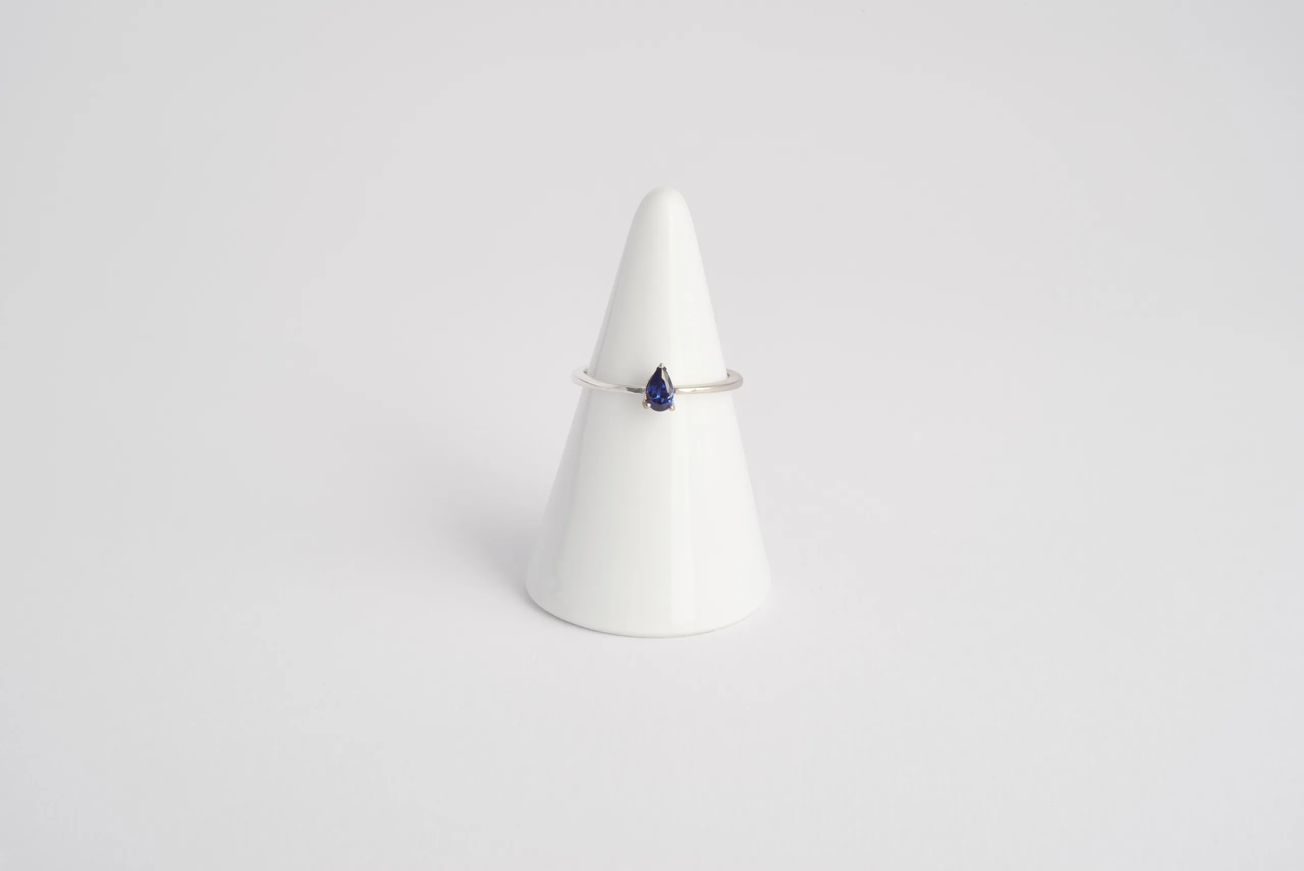 Anello Kai in oro bianco 18kt rodiato con zaffiro blu taglio goccia e gambo a mezza fede, Monica Candido Gioielli Milano - 1